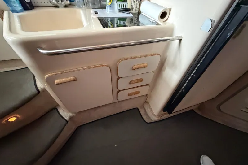 Slide: The Image of 1994 Sea Ray Sundancer 330 interior kitchenette with sink and storage drawers. - 28