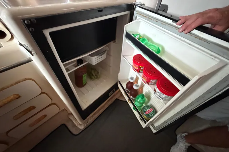 Slide: The Image of Open refrigerator in 1994 Sea Ray Sundancer 330, stocked with condiments and beverages. - 29