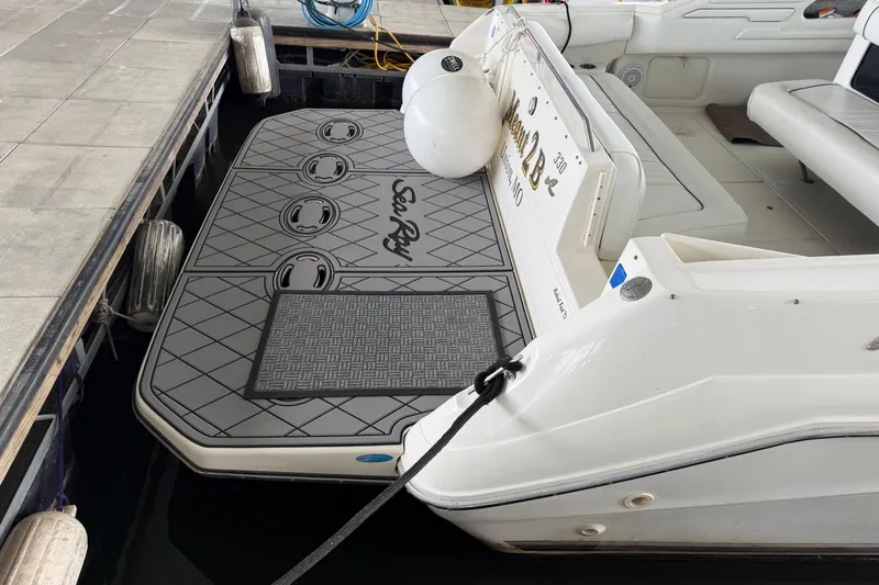 Slide: The Image of 1994 Sea Ray Sundancer 330 docked, featuring a custom swim platform and seating area. - 6