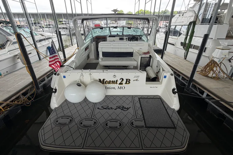 Slide: The Image of 1994 Sea Ray Sundancer 330 docked, rear view with American flag and fenders. - 7