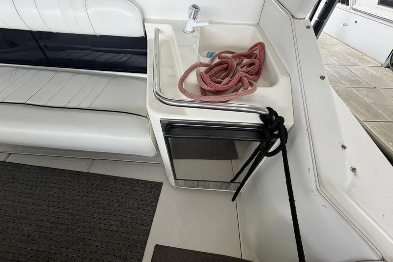 Slide: The Image of 1994 Sea Ray Sundancer 330 interior with seating, sink, and rope storage. - 9