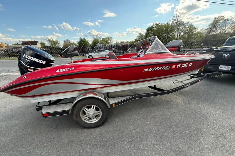 Slide: The Image of 2013 Stratos 486 Ski-N-Fish boat on trailer, red and silver design, parked outdoors. - 19