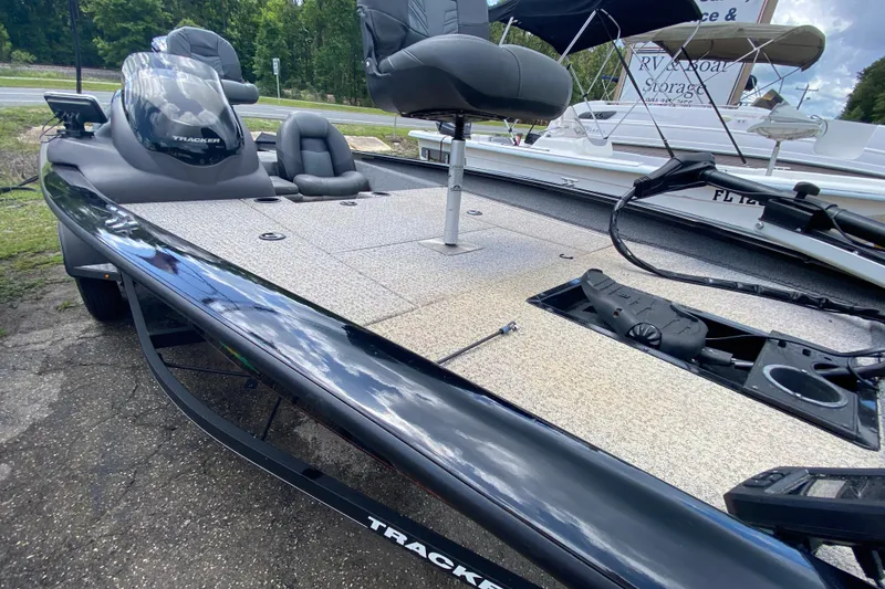 Slide: The Image of 2020 Tracker Pro Team 175 TXW fishing boat with seating and storage, parked outdoors. - 8
