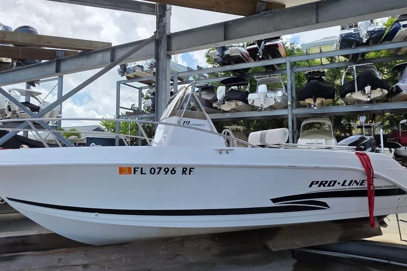 The Image of 2001 Pro-Line 19 Sport boat in storage, white hull, registration FL 0796 RF. - 0