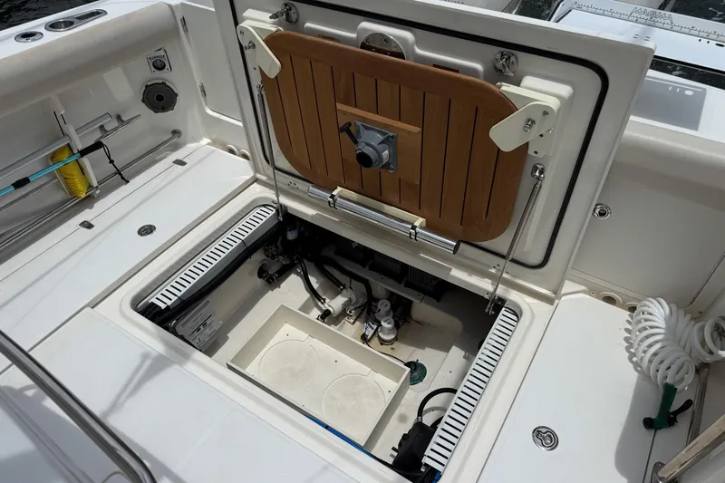 Slide: The Image of 2020 Boston Whaler 330 Outrage boat storage compartment with open hatch and visible equipment. - 12
