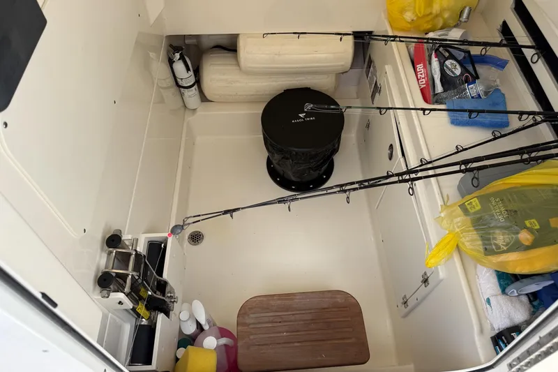 Slide: The Image of Storage compartment of a 2020 Boston Whaler 330 Outrage with fishing gear and supplies. - 14