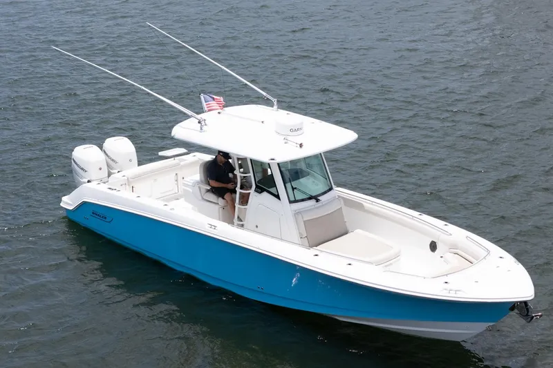 Slide: The Image of 2020 Boston Whaler 330 Outrage boat on water, featuring dual engines and sleek design. - 17