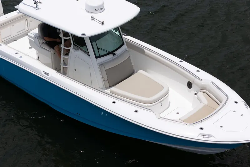 Slide: The Image of 2020 Boston Whaler 330 Outrage boat with blue hull on water. - 18