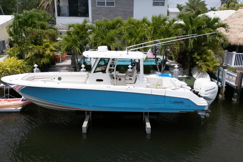 Slide: The Image of 2020 Boston Whaler 330 Outrage boat docked near tropical waterfront home. - 19