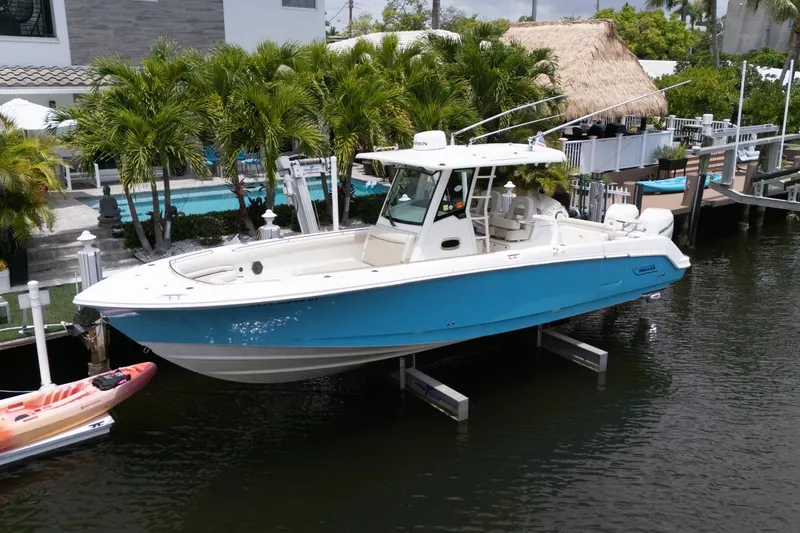 Slide: The Image of 2020 Boston Whaler 330 Outrage boat docked by tropical waterfront home. - 3