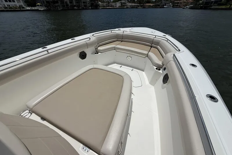 Slide: The Image of 2020 Boston Whaler 330 Outrage boat interior with cushioned seating and waterfront view. - 8