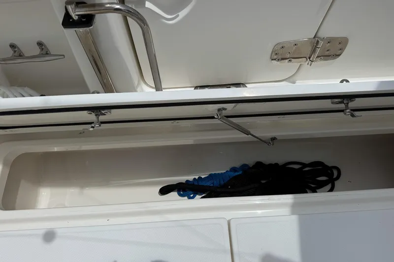 Slide: The Image of Open storage compartment on 2020 Boston Whaler 330 Outrage boat with ropes inside. - 9