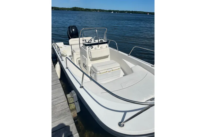 Slide: The Image of 2010 Boston Whaler 170 Montauk boat docked by a serene lake. - 2