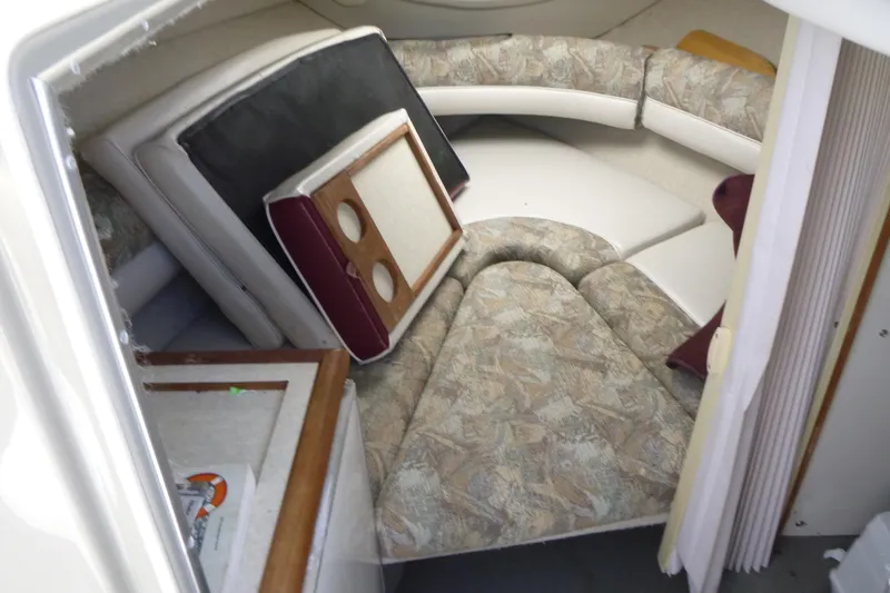 Slide: The Image of 1998 Maxum 2300 SC cabin interior with cushions and table setup. - 12