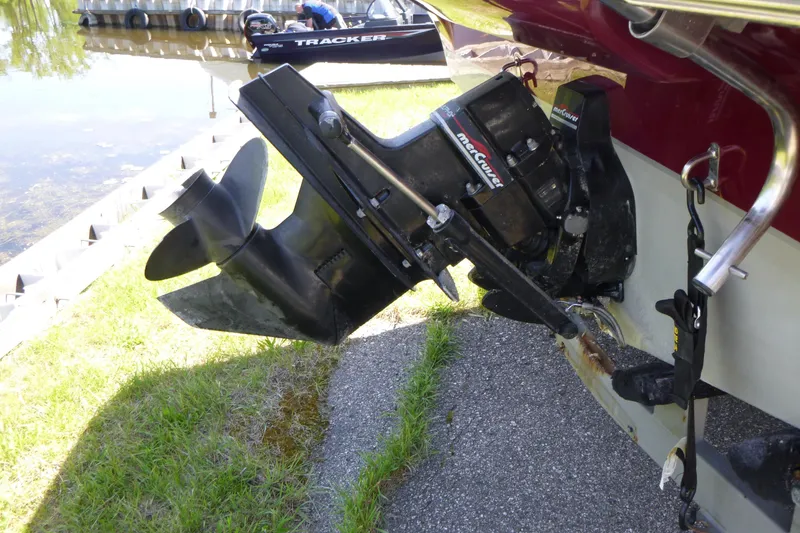 Slide: The Image of Outboard motor of a 1998 Maxum 2300 SC boat near a lakeside dock. - 14