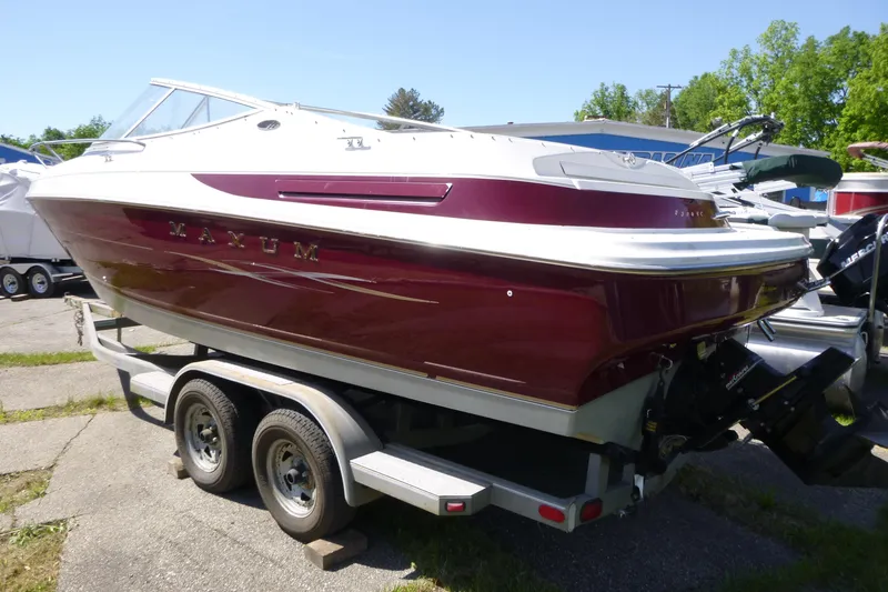 Slide: The Image of 1998 Maxum 2300 SC boat on trailer, maroon and white, parked outdoors. - 3