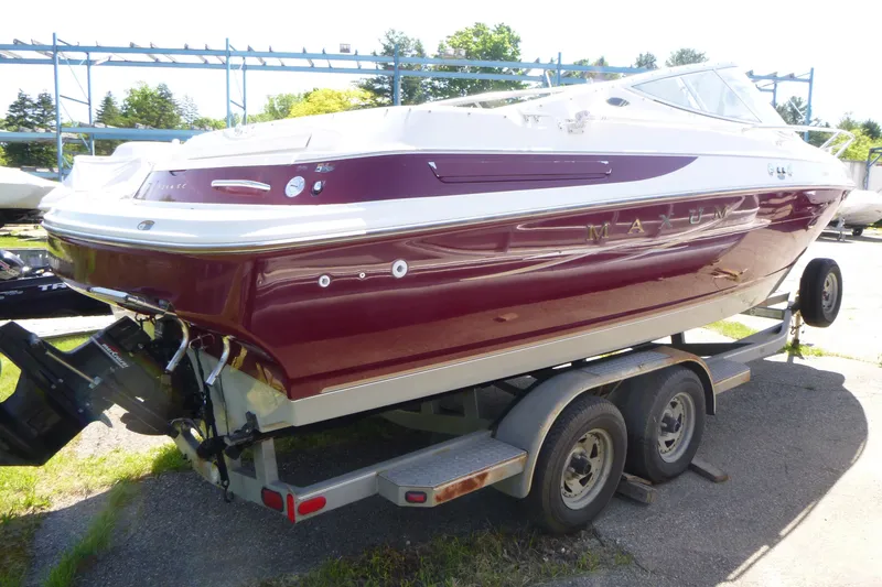 Slide: The Image of 1998 Maxum 2300 SC boat on trailer, maroon and white exterior, parked outdoors. - 4