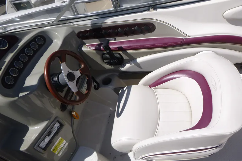 Slide: The Image of 1998 Maxum 2300 SC boat interior with steering wheel and white seat. - 8
