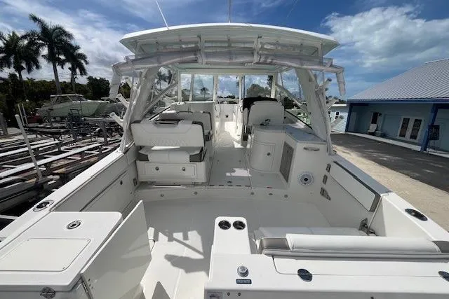 Slide: The Image of 2023 World Cat 325 DC boat interior with seating and helm, docked under a blue sky. - 10