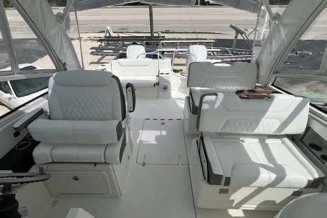 Slide: The Image of 2023 World Cat 325 DC boat interior with white seating and helm station. - 6