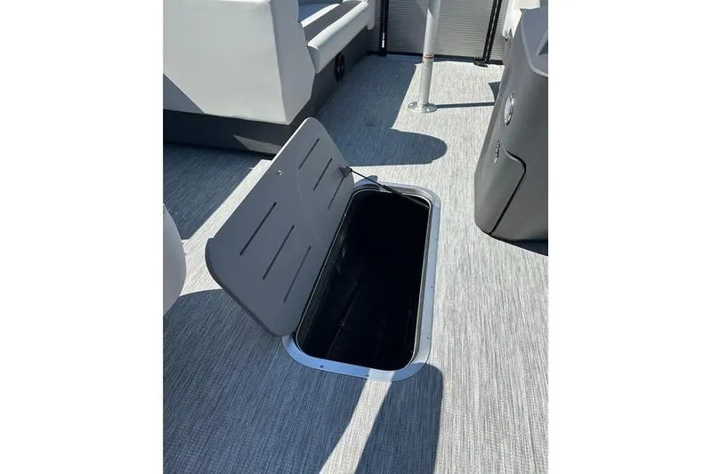 Slide: The Image of Open storage compartment on 2026 Bennington 22 S Quad Bench boat, featuring sleek interior design. - 11