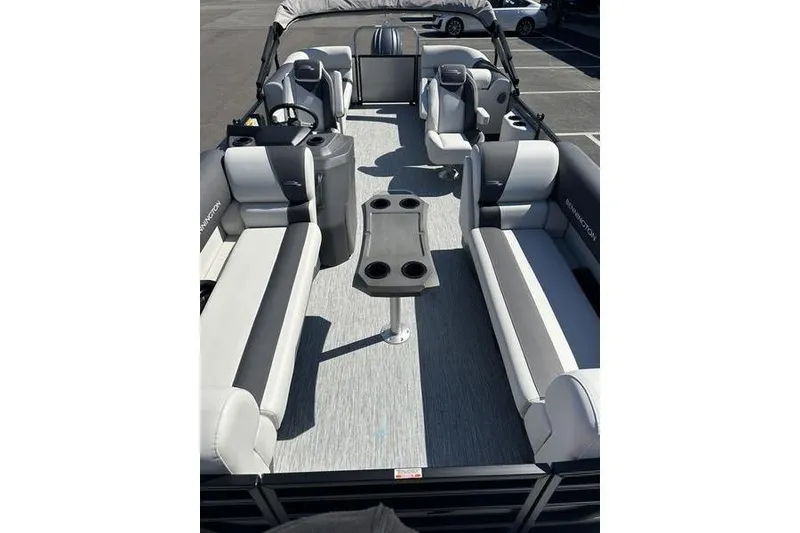 Slide: The Image of 2026 Bennington 22 S Quad Bench pontoon boat interior with spacious seating and table. - 12