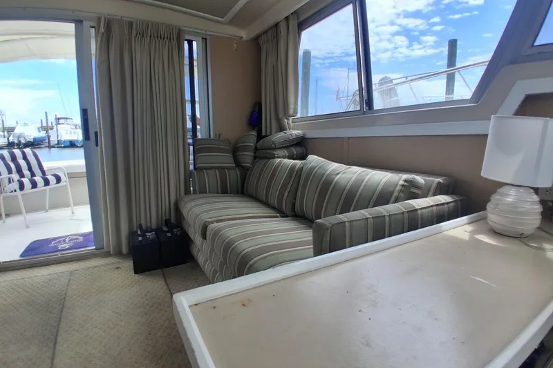 Slide: The Image of Interior of 1986 Silverton 34 Convertible yacht with striped sofa and marina view. - 10