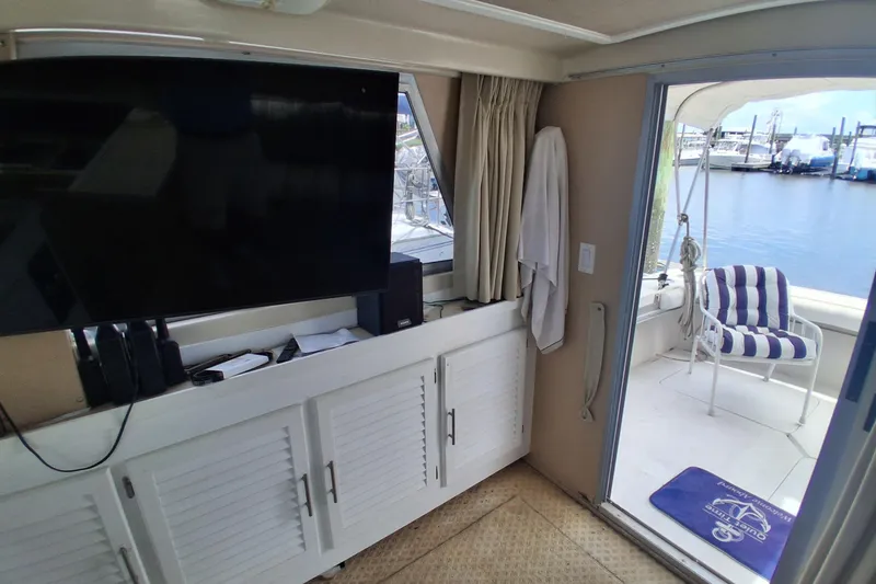 Slide: The Image of Interior view of 1986 Silverton 34 Convertible yacht with TV and marina backdrop. - 13
