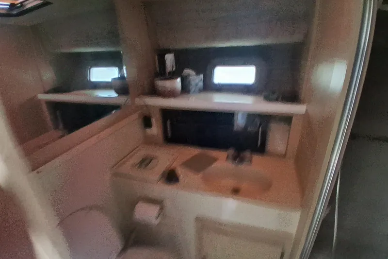 Slide: The Image of 1986 Silverton 34 Convertible boat bathroom with sink, mirror, and window. - 16