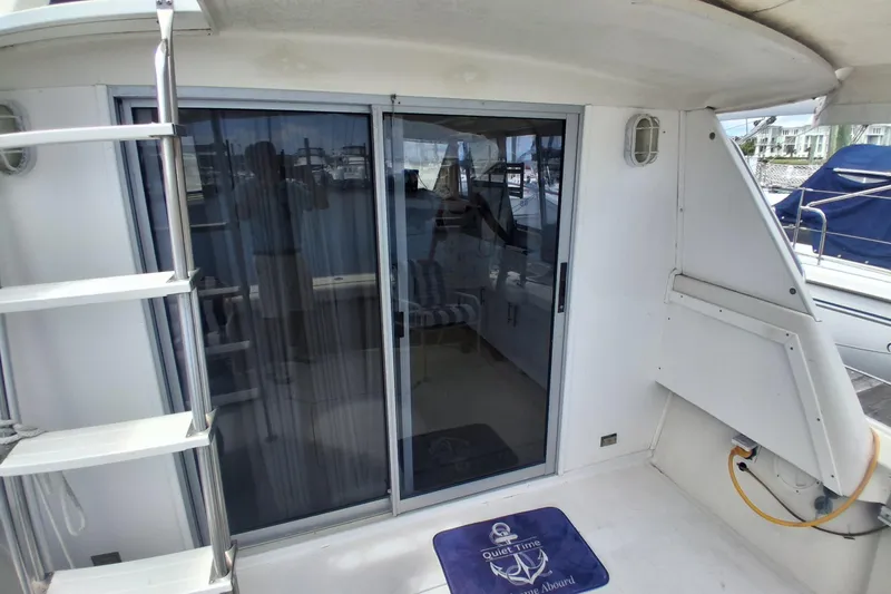 Slide: The Image of 1986 Silverton 34 Convertible yacht deck with sliding glass door and ladder. - 6