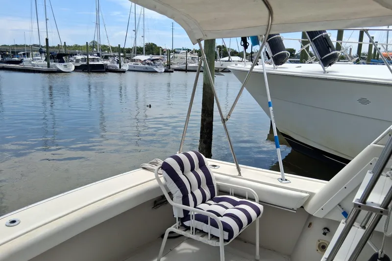 Slide: The Image of 1986 Silverton 34 Convertible boat docked at marina with striped chair on deck. - 7
