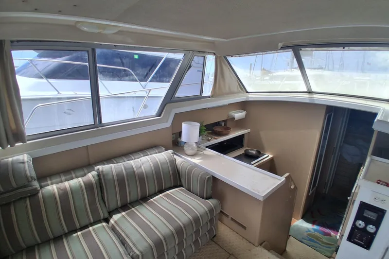 Slide: The Image of Interior of 1986 Silverton 34 Convertible yacht with striped sofa and compact kitchen area. - 8