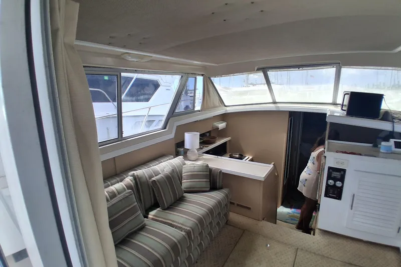 Slide: The Image of Interior of 1986 Silverton 34 Convertible yacht with striped seating and nautical decor. - 9