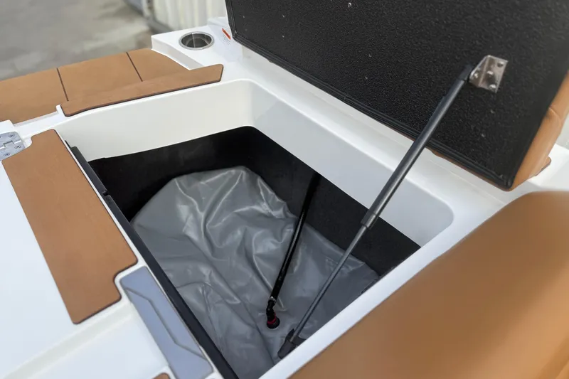 Slide: The Image of Open storage compartment in 2022 Axis T250 boat with brown seating. - 18
