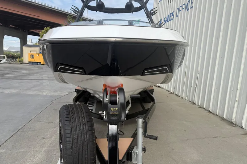 Slide: The Image of 2022 Axis T250 boat on trailer near sales office, under overpass. - 2