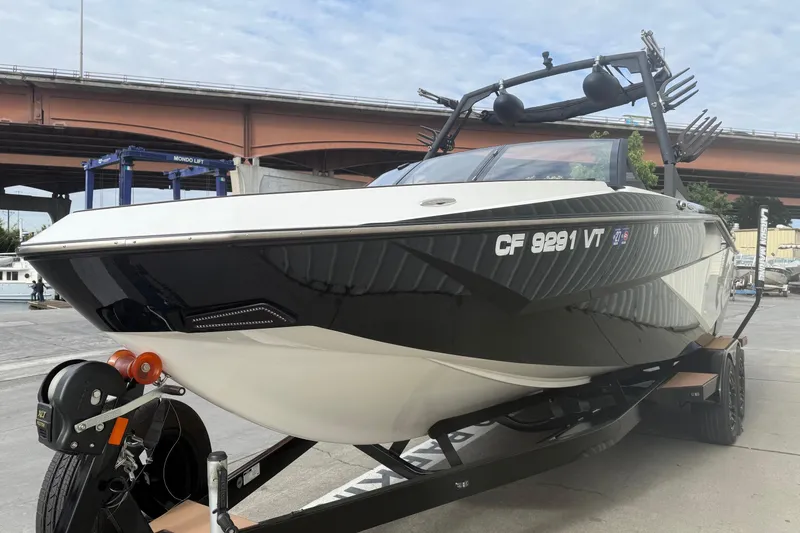 Slide: The Image of 2022 Axis T250 boat on trailer under bridge, showcasing sleek design and modern features. - 3