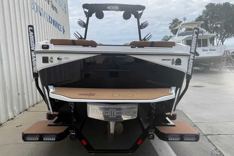 Slide: The Image of 2022 Axis T250 boat rear view at marina, featuring Larson Marine branding. - 5