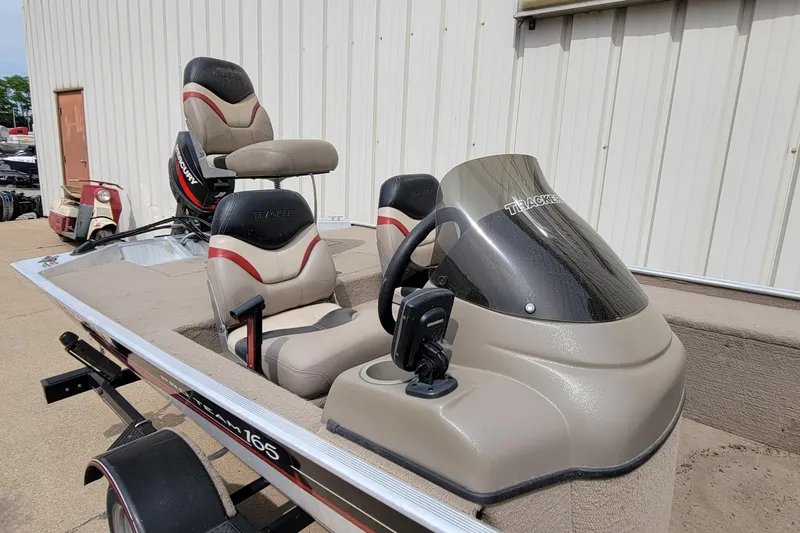 Slide: The Image of 2003 Tracker Pro Team 165 boat with seating and console, parked outdoors. - 18