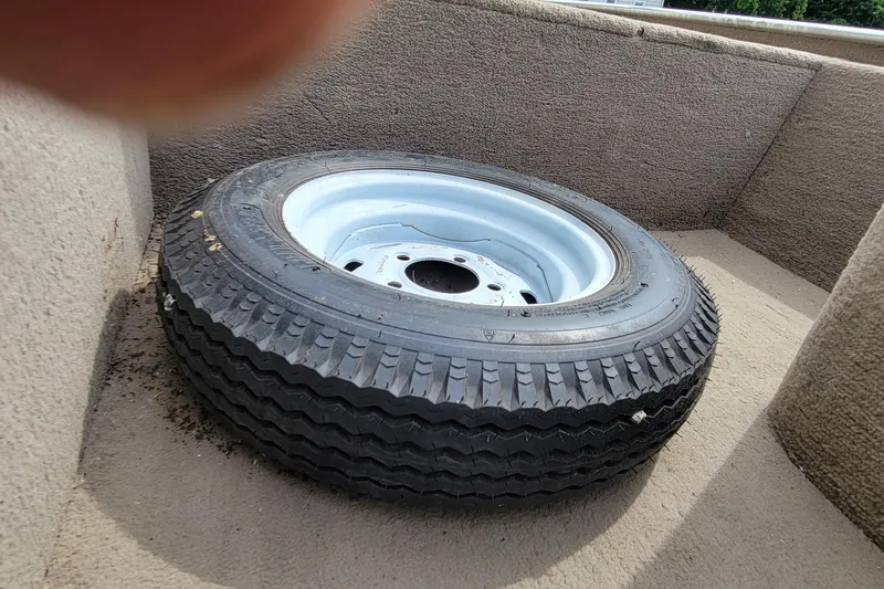 Slide: The Image of Spare tire on a 2003 Tracker Pro Team 165 boat deck. - 25