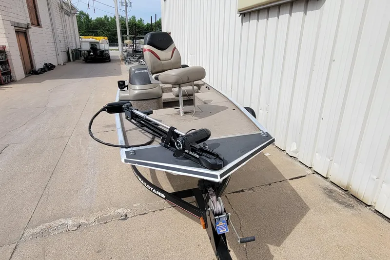 Slide: The Image of 2003 Tracker Pro Team 165 boat parked outdoors, featuring a trolling motor and seating. - 5