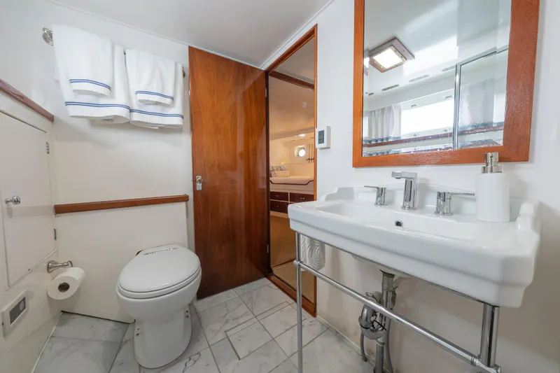 Slide: The Image of Bathroom interior of 1939 Mathis Trumpy Fantail Houseboat with modern fixtures and wooden accents. - 14