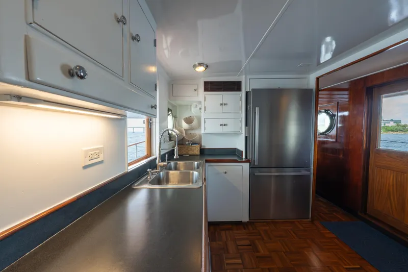 Slide: The Image of Interior of 1939 Mathis Trumpy Fantail Houseboat with modern kitchen and stainless steel appliances. - 17