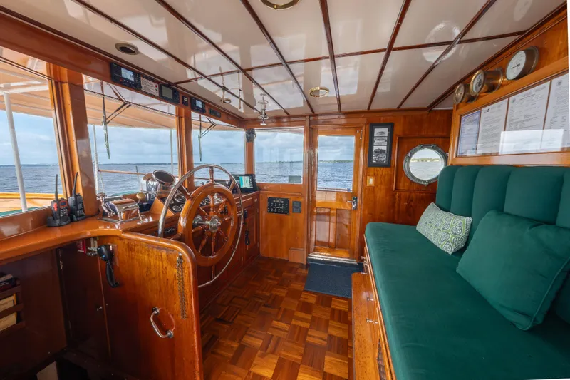Slide: The Image of Interior of 1939 Mathis Trumpy Fantail Houseboat with wooden helm and green seating. - 19