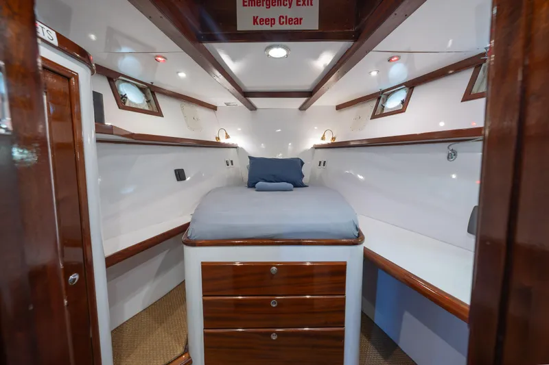 Slide: The Image of 1939 Mathis Trumpy Fantail Houseboat cabin with wooden accents and cozy bed. - 22