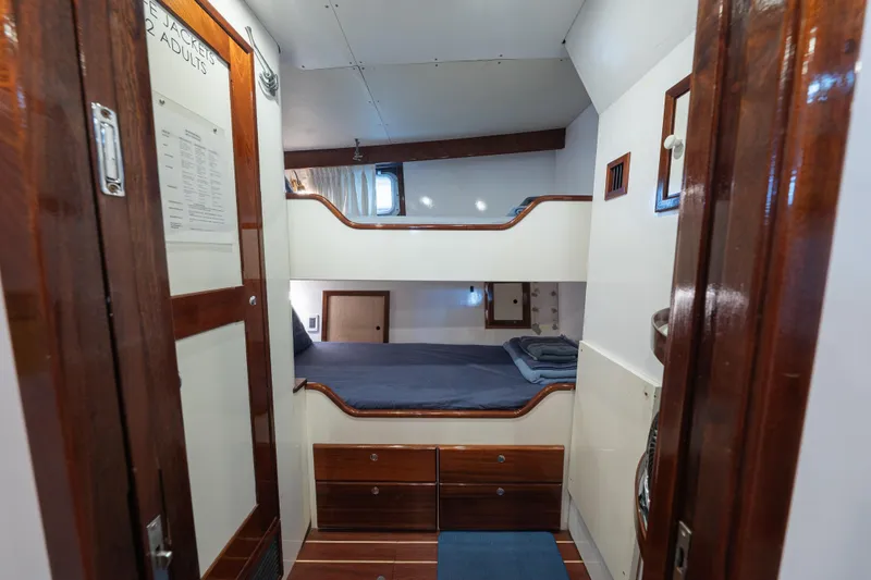 Slide: The Image of Interior of 1939 Mathis Trumpy Fantail Houseboat with wooden bunk beds and storage. - 24