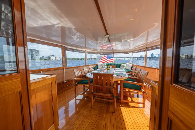 Slide: The Image of Elegant 1939 Mathis Trumpy Fantail Houseboat interior with wooden dining area and scenic water views. - 30