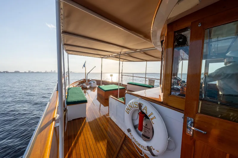 Slide: The Image of 1939 Mathis Trumpy Fantail Houseboat on serene water, featuring wooden deck and canopy. - 34