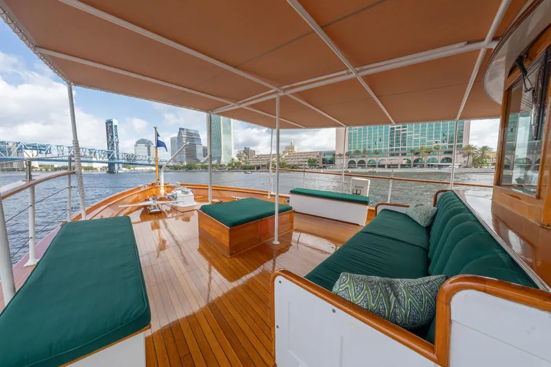 Slide: The Image of 1939 Mathis Trumpy Fantail Houseboat with elegant deck, city skyline view, and comfortable seating. - 35