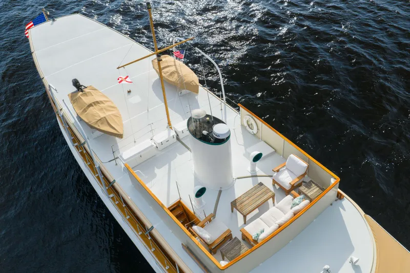 Slide: The Image of 1939 Mathis Trumpy Fantail Houseboat on water, featuring deck seating and lifeboats. - 38
