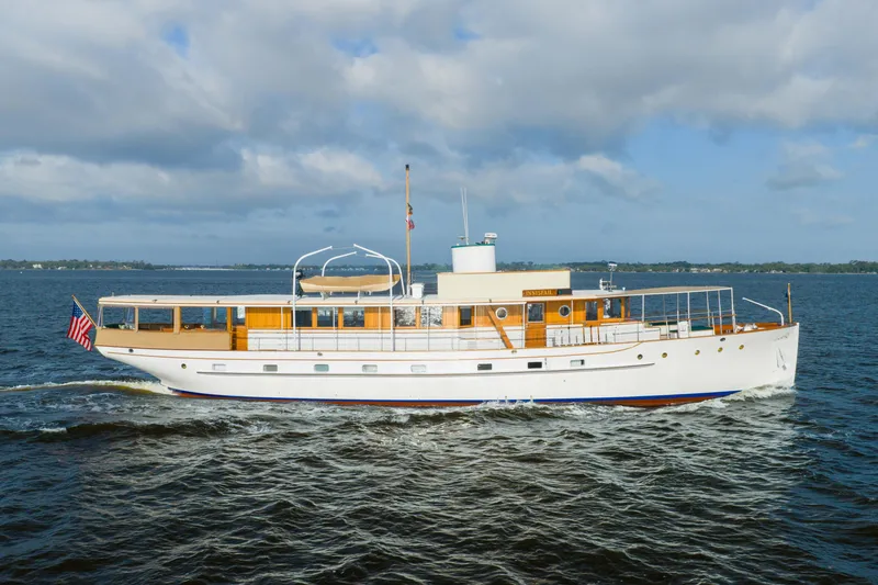 Slide: The Image of 1939 Mathis Trumpy Fantail Houseboat cruising on open water under a cloudy sky. - 39